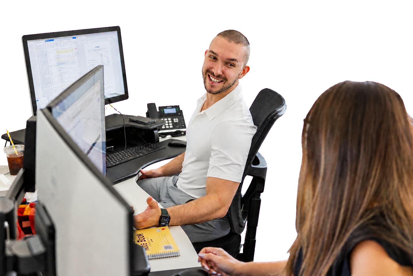 A Consolidated Insurance Brokers account manager at their workstation, turning to talk with the person beside them